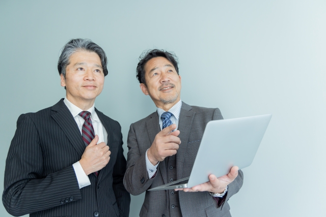 スーツ姿の男性二人が相談するビジネスシーン