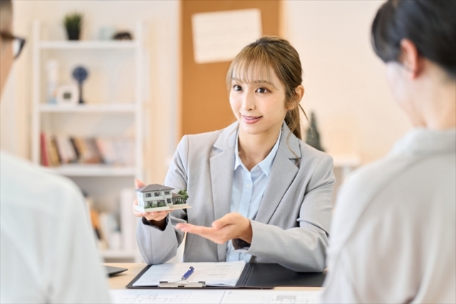 住宅模型を持つ女性社員