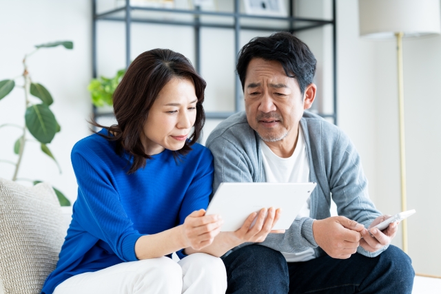 タブレットを見る夫婦