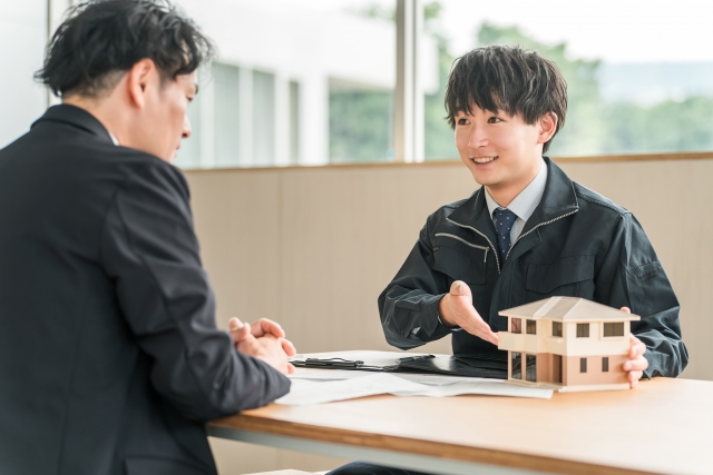 住宅模型を使って説明する男性