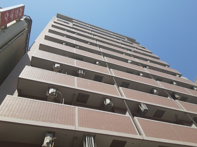 青空にそびえる茶色の高層マンション
