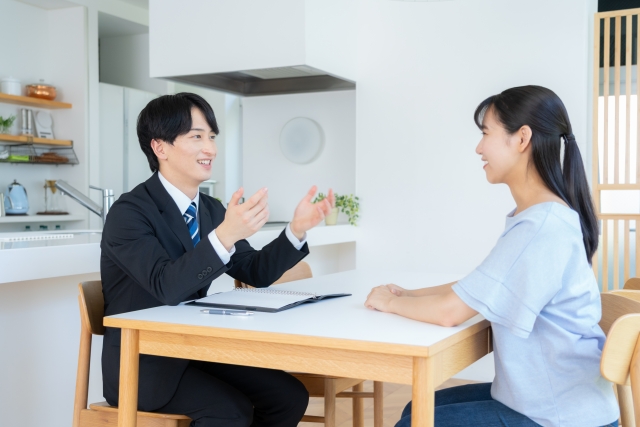 自宅で不動産相談を受ける女性と担当者