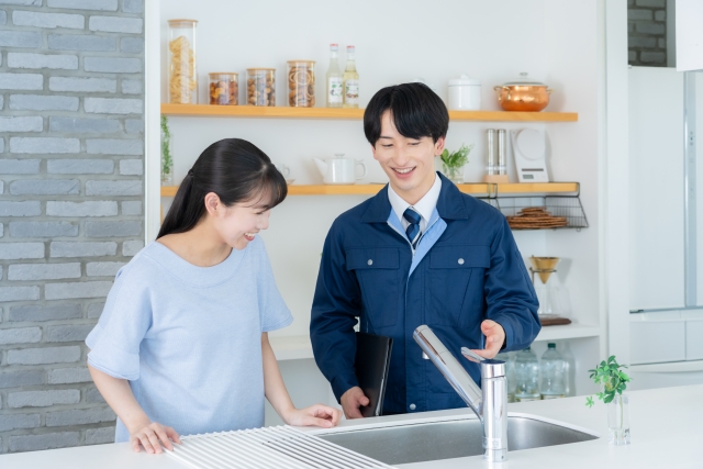 キッチン設備を説明する担当者と女性